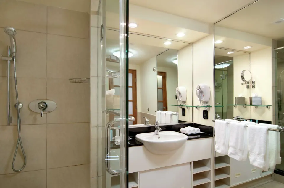 Executive Room bathroom vanity and glass shower at Hilton Trinidad & Conference Centre.