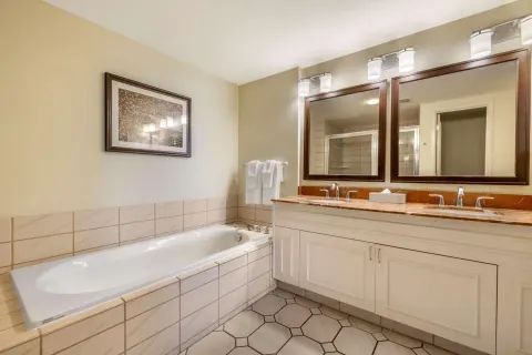 Guest bathroom with soaking tub and double vanity at Hilton Vacation Club The Point At Poipu Kauai.