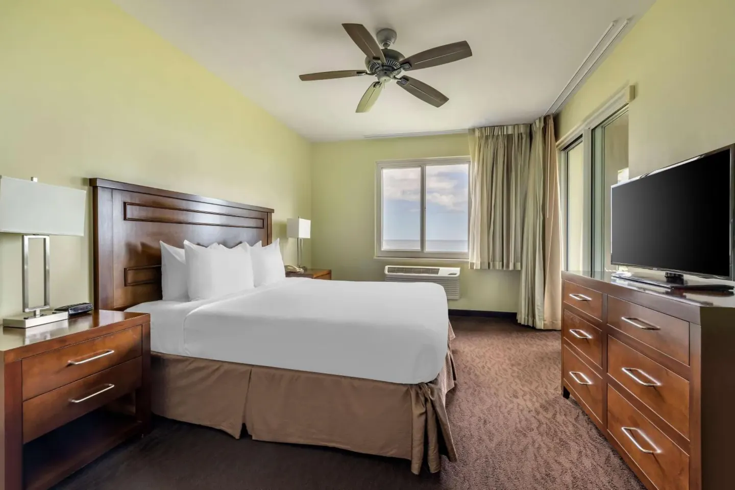 King bedroom with TV and window at Hilton Vacation Club The Point At Poipu Kauai.