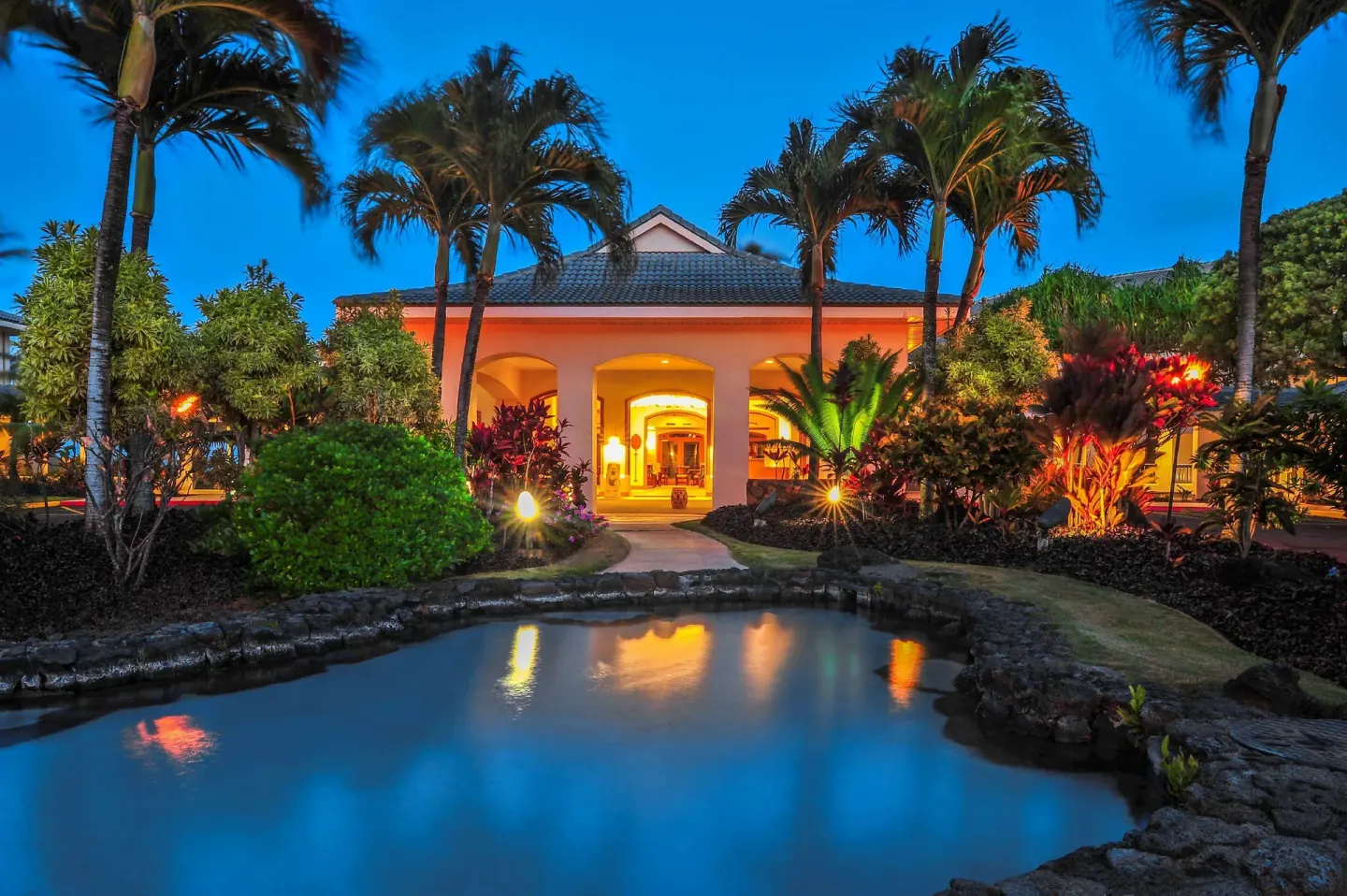 Illuminated resort entrance and lagoon at Hilton Vacation Club The Point At Poipu Kauai.