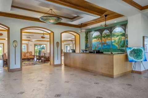Lobby reception desk with mural and arched openings at Hilton Vacation Club The Point At Poipu Kauai.