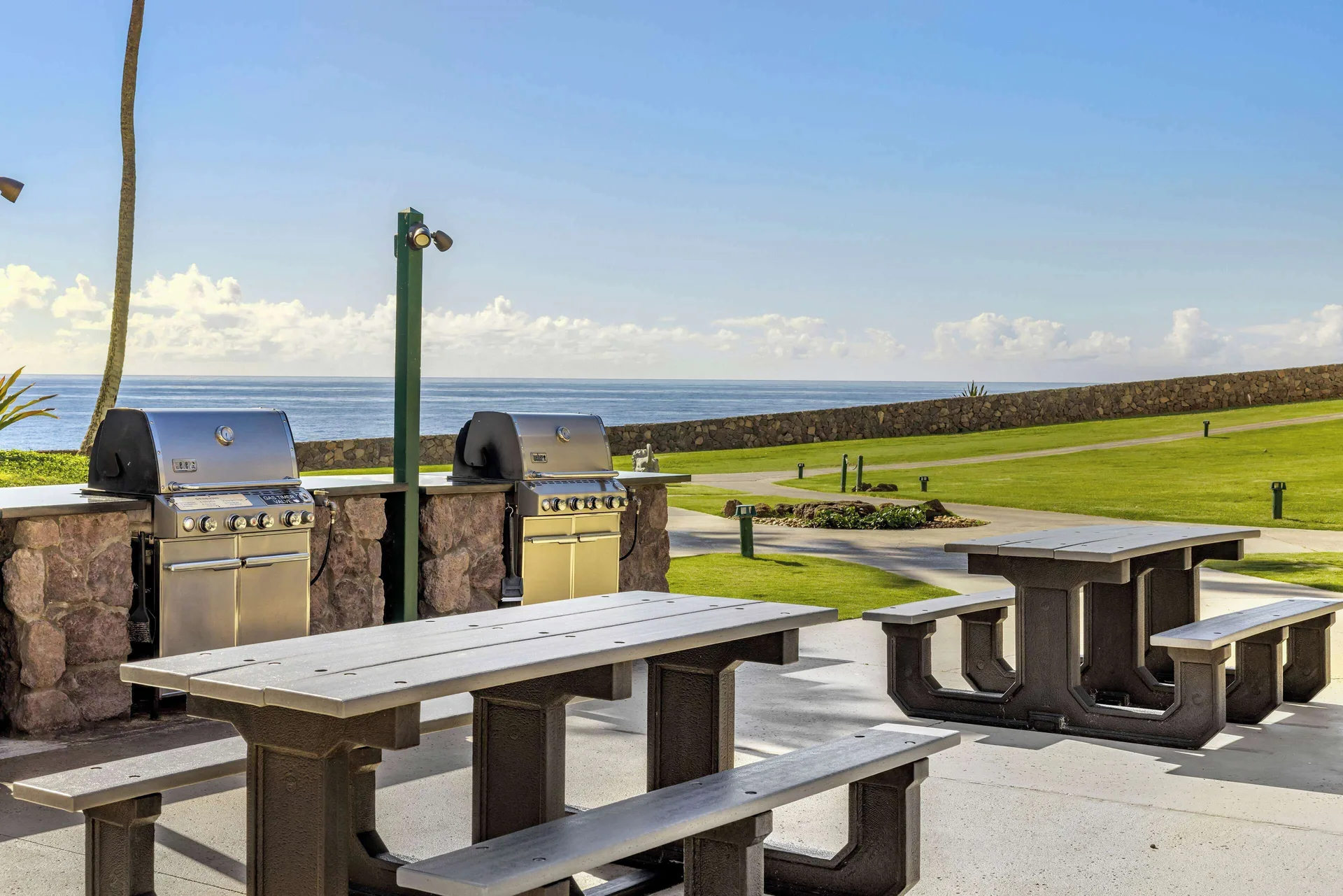 Oceanfront barbecue grills and picnic tables at Hilton Vacation Club The Point At Poipu Kauai.