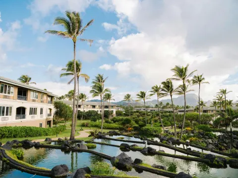 Palm-lined lagoon gardens at Hilton Vacation Club The Point At Poipu Kauai.