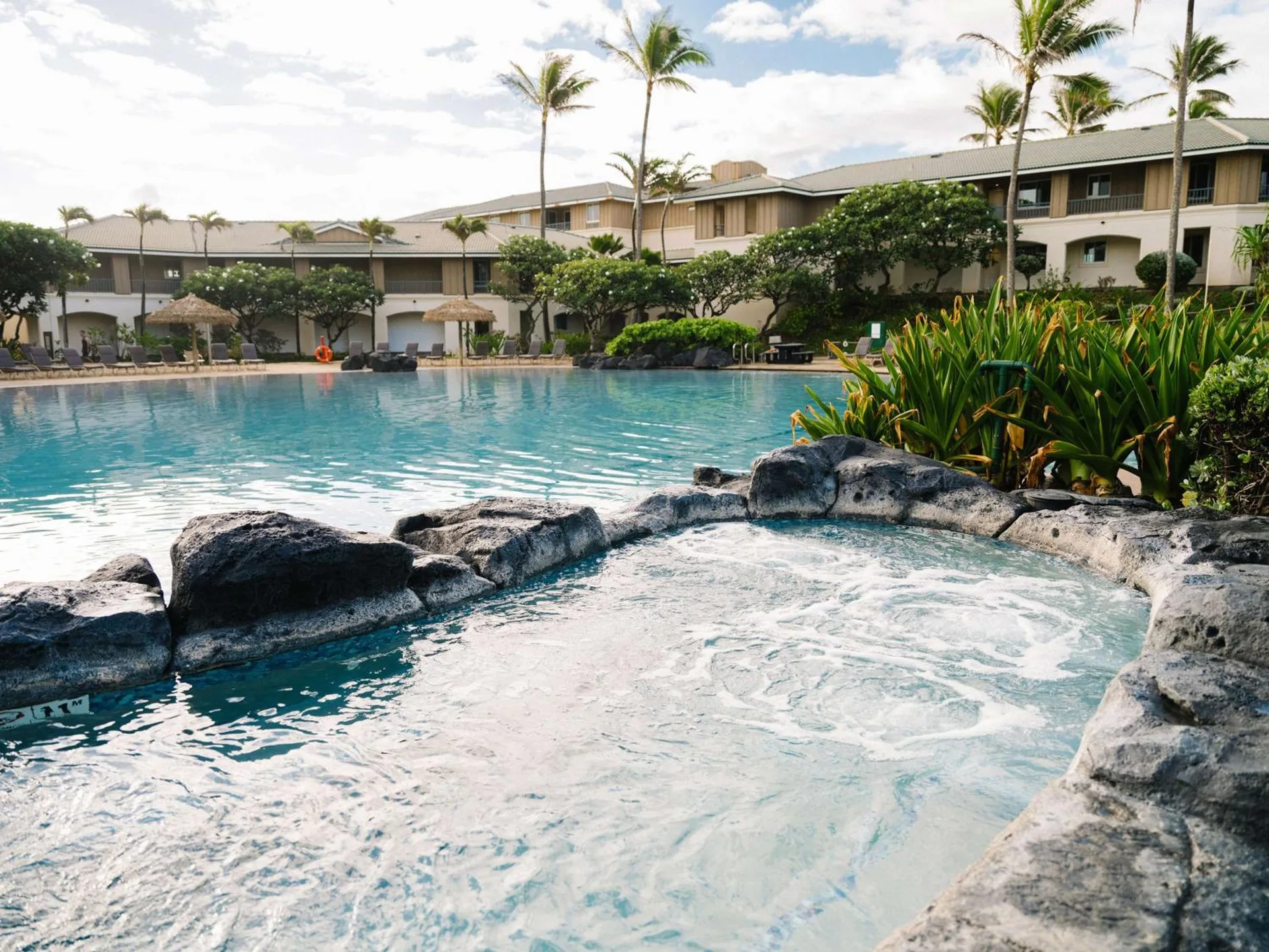 Pool and rock-edged spa at Hilton Vacation Club The Point At Poipu Kauai.