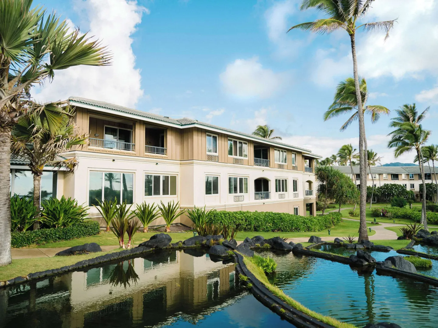 Resort building and landscaped lagoon at Hilton Vacation Club The Point At Poipu Kauai.
