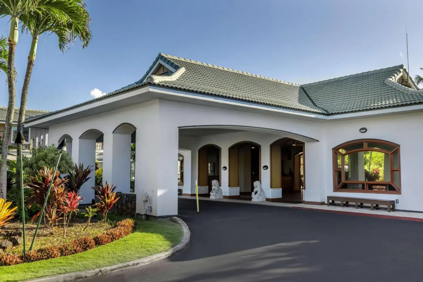 Covered resort entrance with landscaped drive at Hilton Vacation Club The Point At Poipu Kauai.