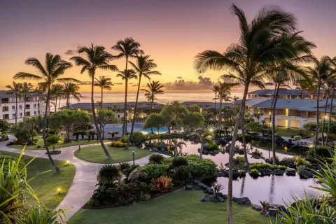 Resort grounds, lagoons, palms, and ocean at sunset at Hilton Vacation Club The Point At Poipu Kauai.