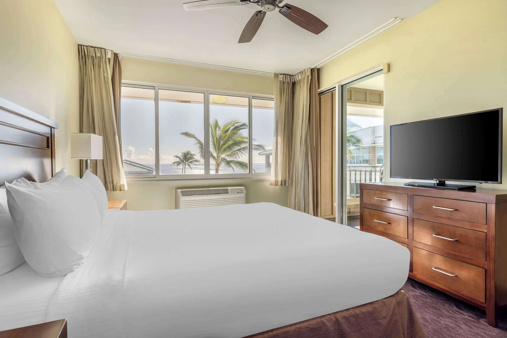 King bedroom with ocean-facing windows at Hilton Vacation Club The Point At Poipu Kauai.