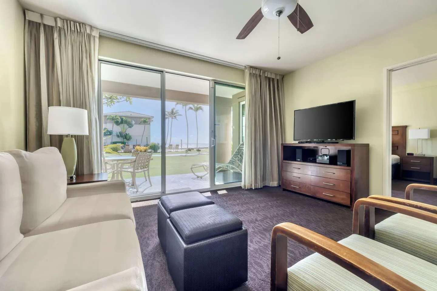 Living room with patio doors and ocean glimpse at Hilton Vacation Club The Point At Poipu Kauai.