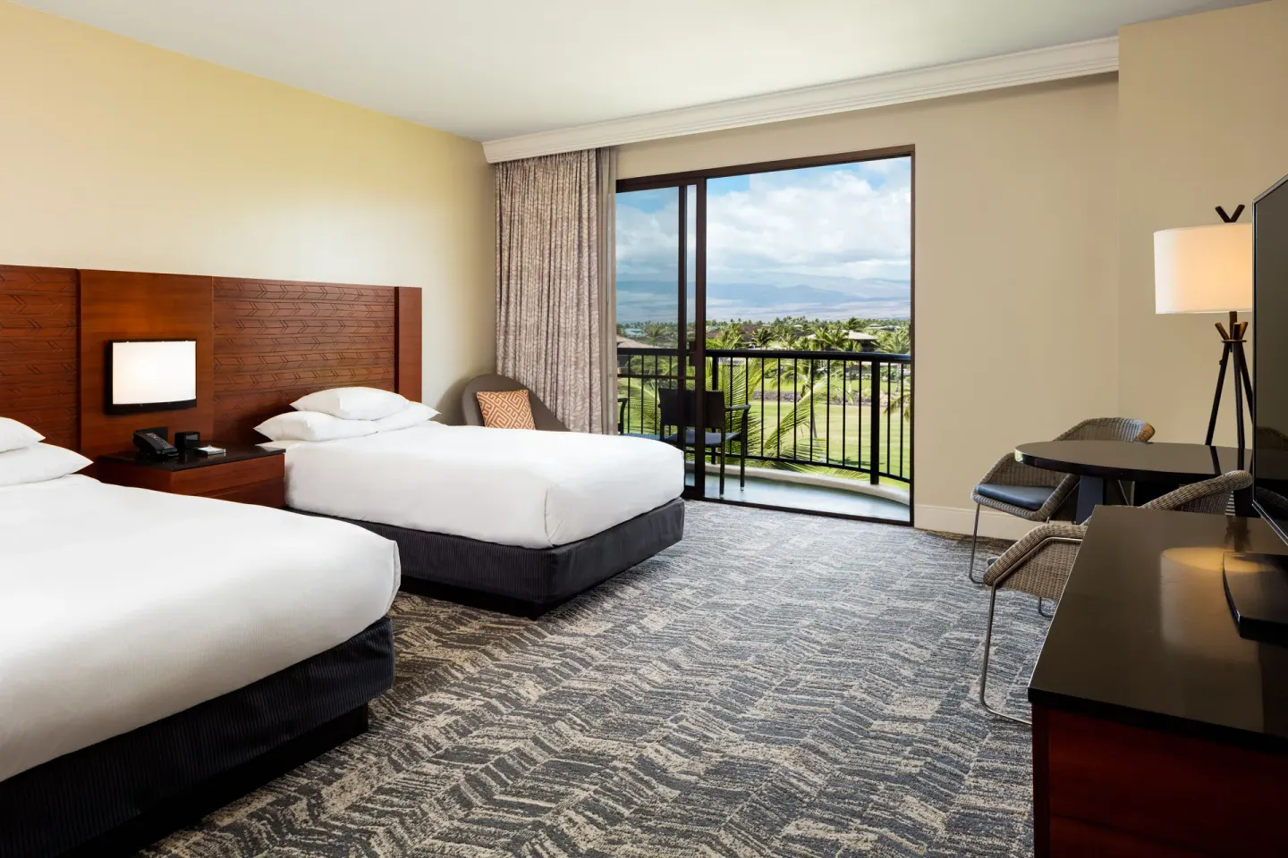 Two-bed guest room with balcony and golf course view at Hilton Waikoloa Village.