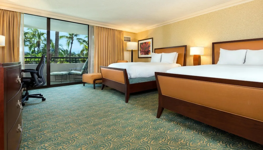 Two-bed guest room with balcony and palm views at Hilton Waikoloa Village.
