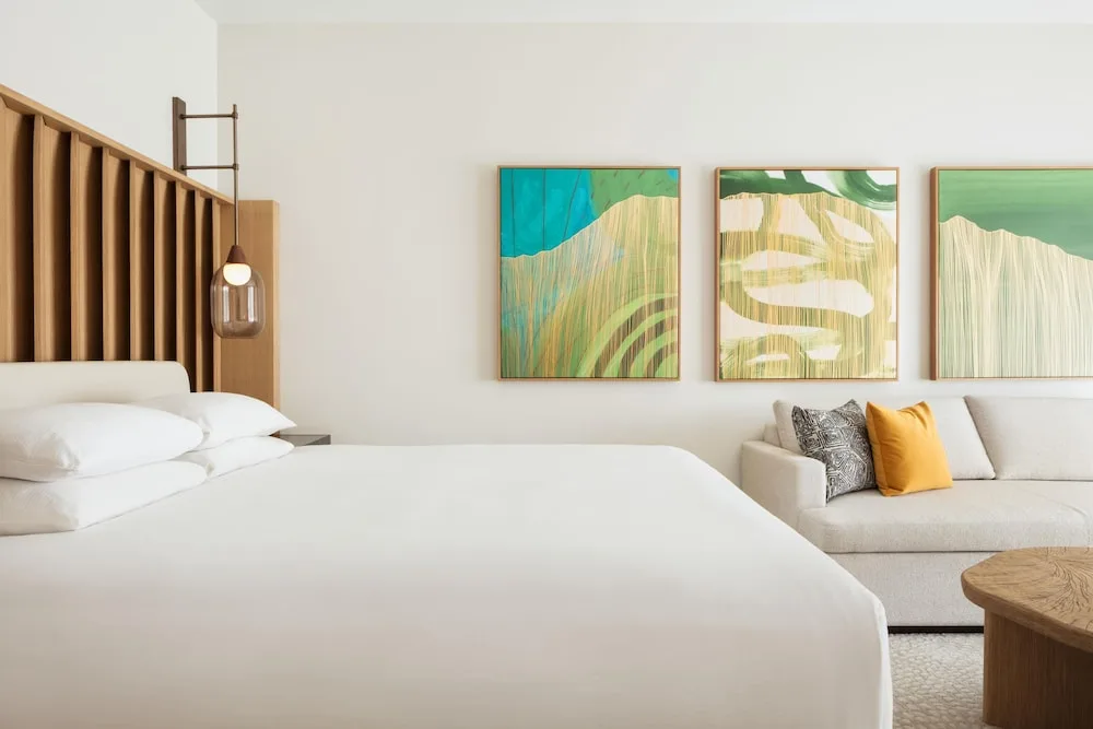 King guest room with sofa and abstract wall art at Hilton Waikoloa Village.