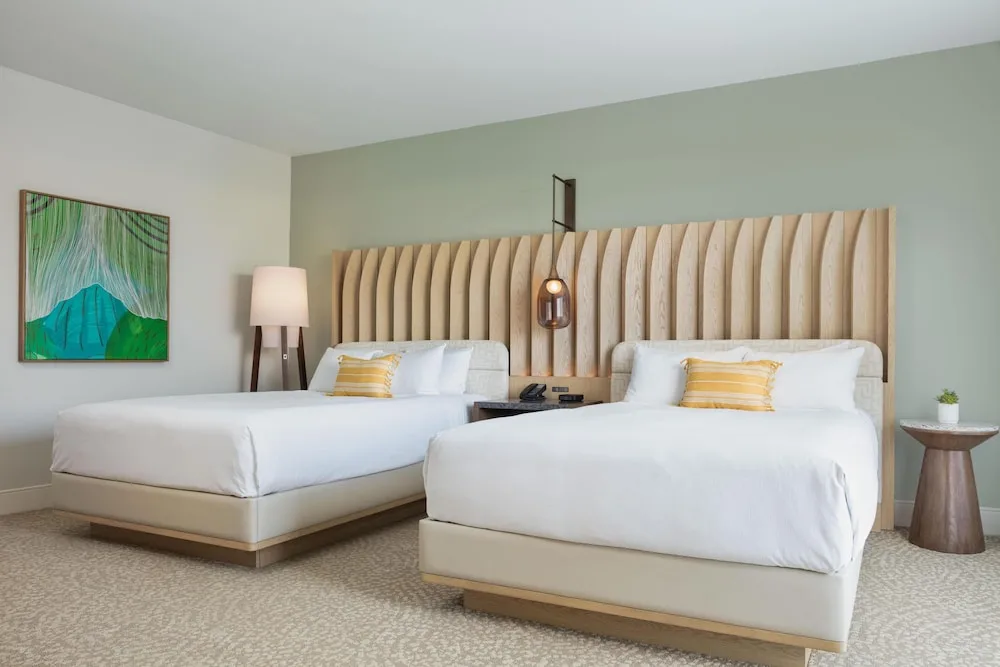 Two-bed guest room with botanical artwork at Hilton Waikoloa Village.