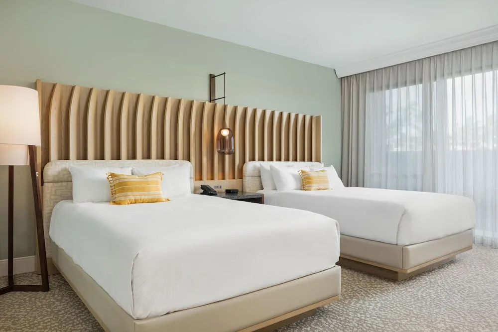 Two-bed guest room with pale green walls at Hilton Waikoloa Village.