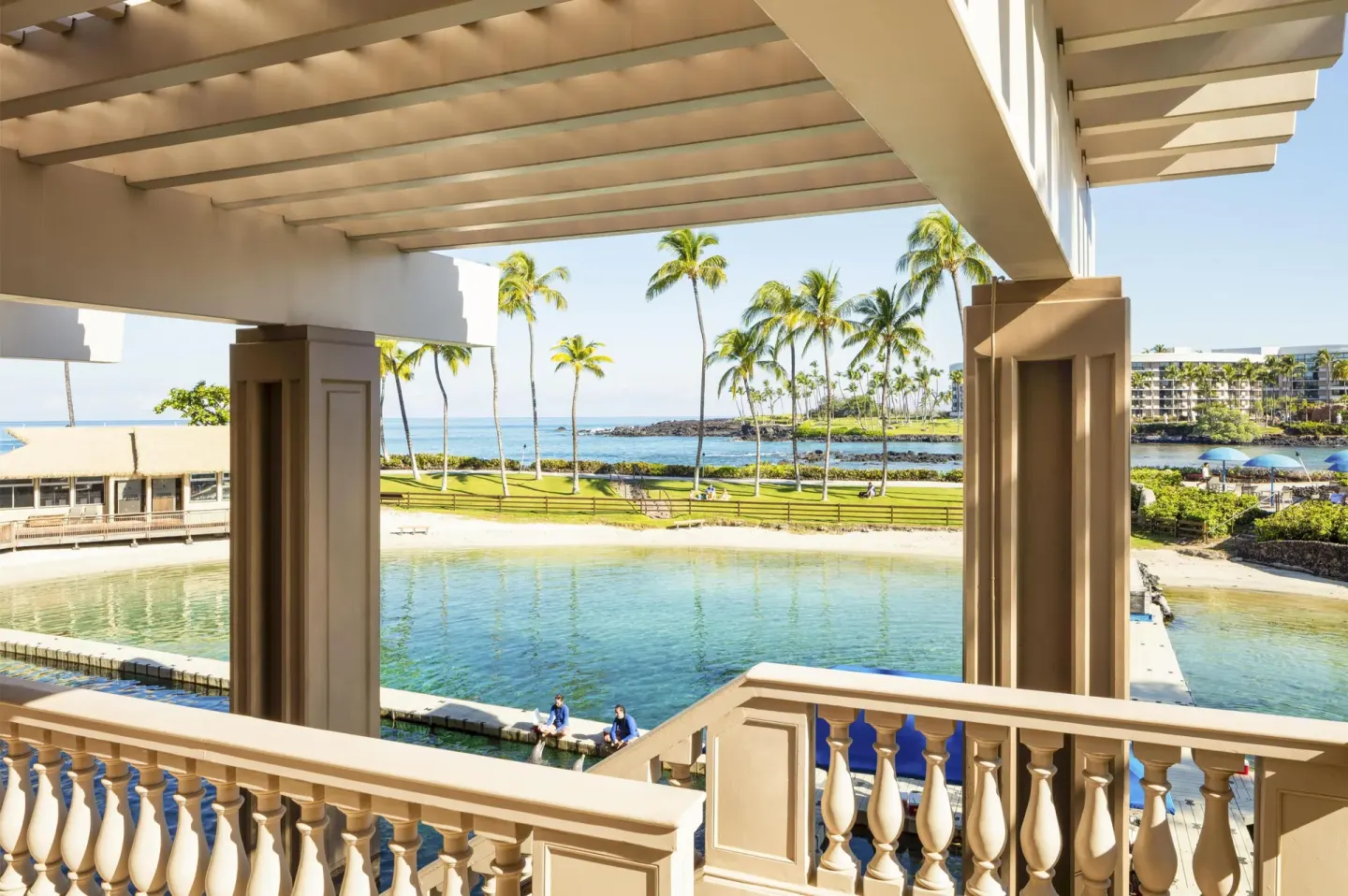 Covered lanai overlooks the lagoon, palms, and ocean at Hilton Waikoloa Village.