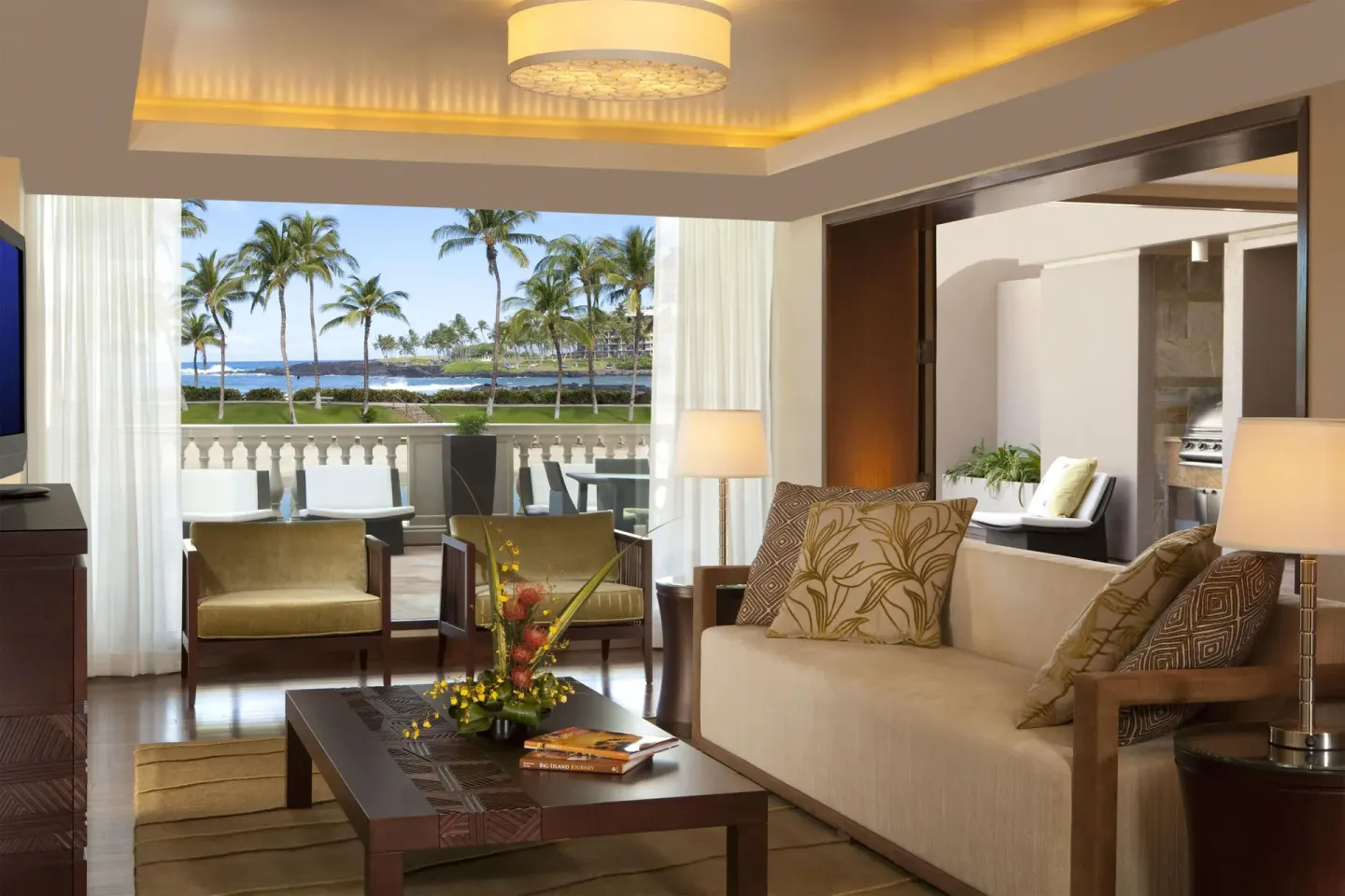 Living room with sofa and balcony ocean view at Hilton Waikoloa Village.
