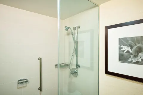 Makai Owner Suite glass shower with wall-mounted hand shower at Hilton Waikoloa Village.