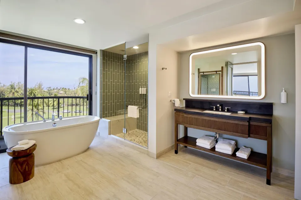 Makai One Bedroom Suite bathroom with tub and shower at Hilton Waikoloa Village