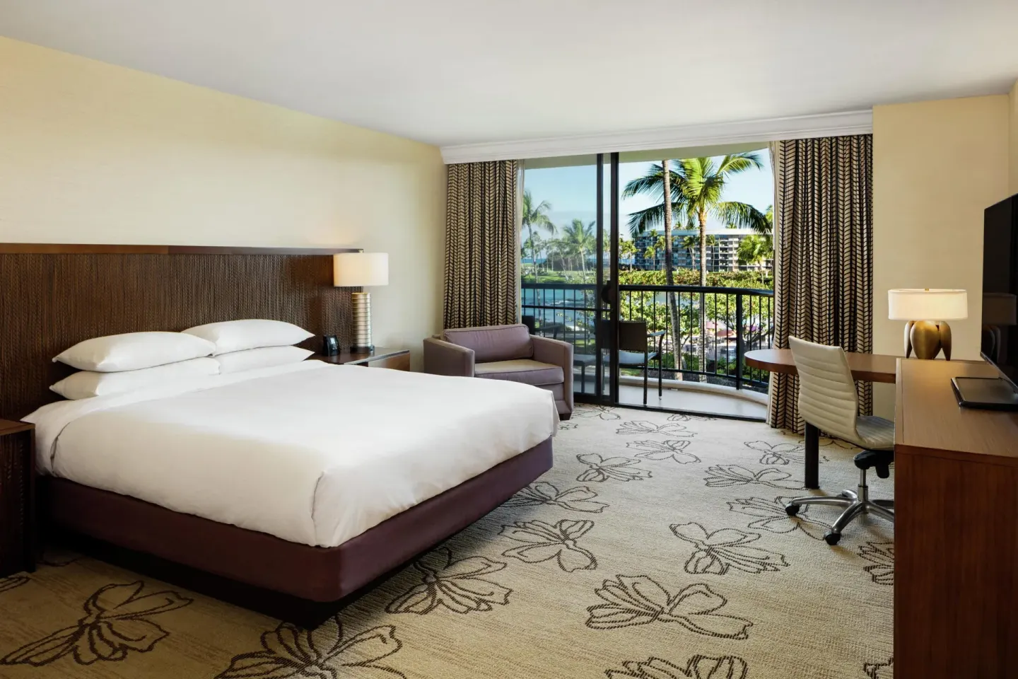 Makai Ocean View king room with desk, chair and balcony at Hilton Waikoloa Village.