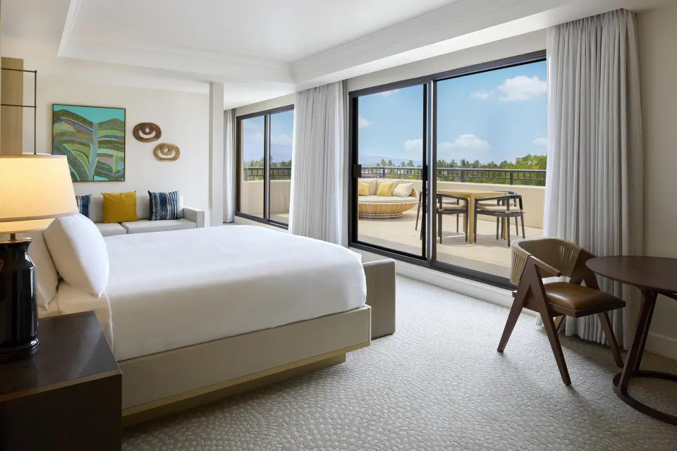 Palace Presidential Suite bedroom with balcony doors at Hilton Waikoloa Village.