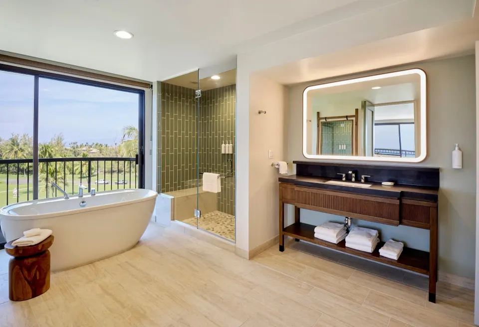 Bathroom tub, glass shower, and vanity in the Palace Presidential Suite at Hilton Waikoloa Village.