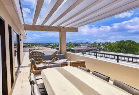 Furnished terrace with dining table and ocean view at Hilton Waikoloa Village.