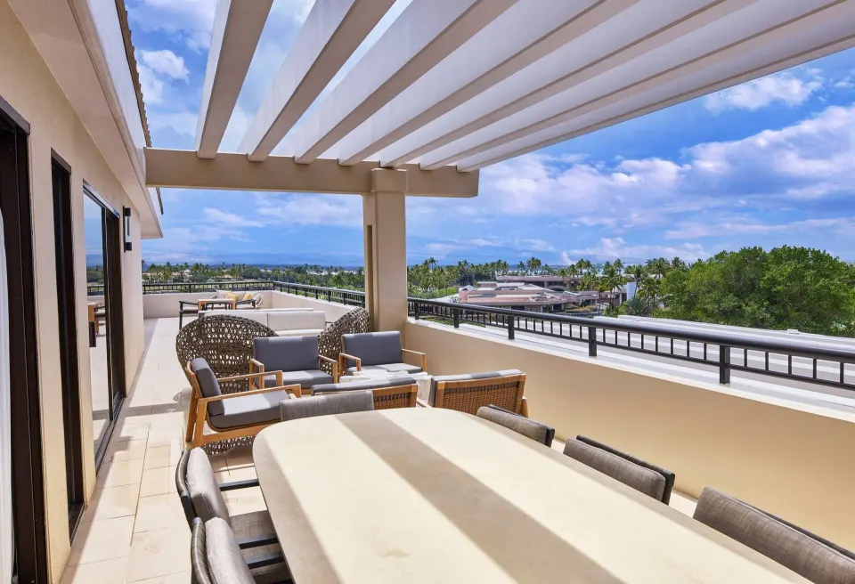 Furnished terrace with dining table and ocean view at Hilton Waikoloa Village.