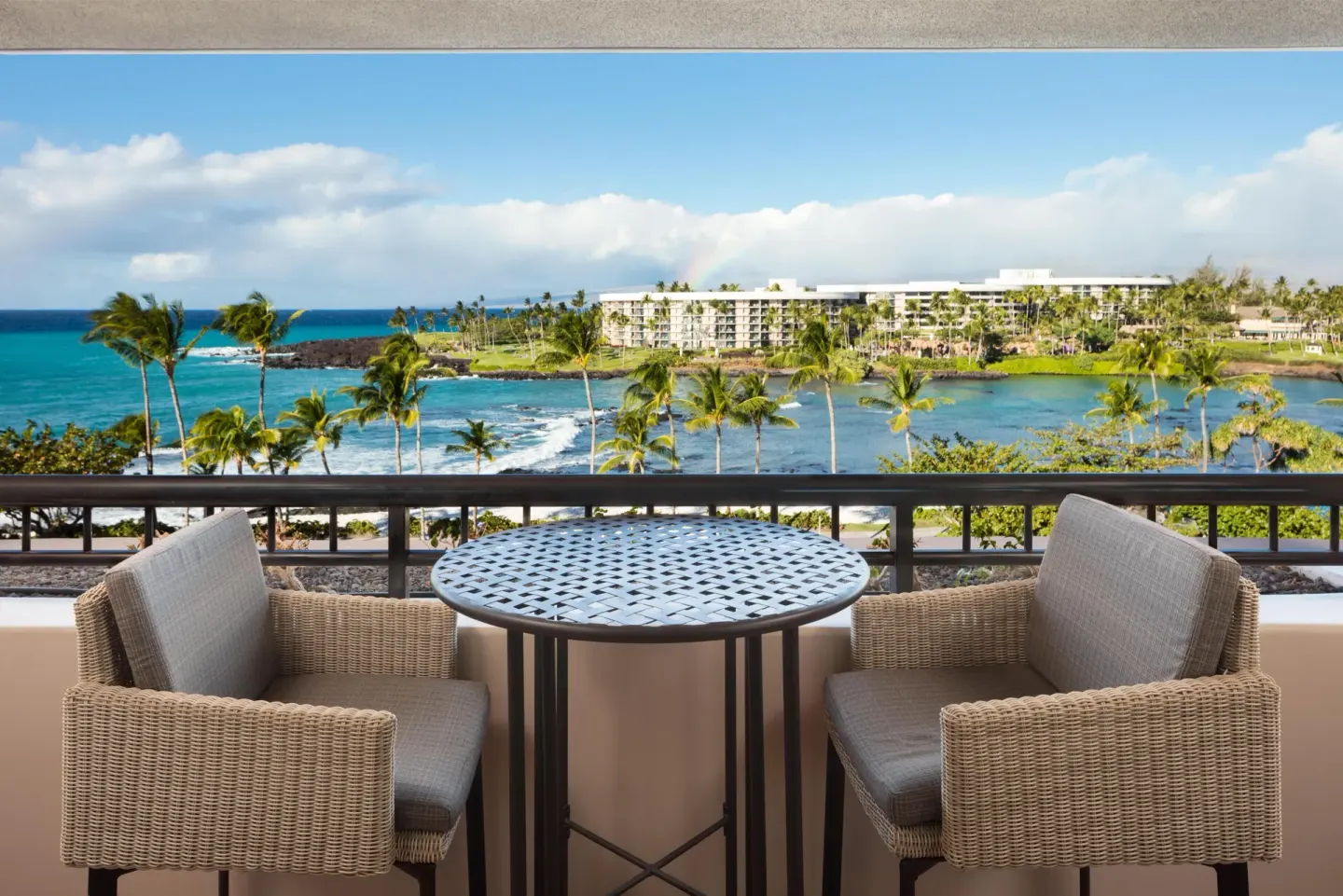 Ocean-view balcony table and chairs in the Presidential Suite at Hilton Waikoloa Village.