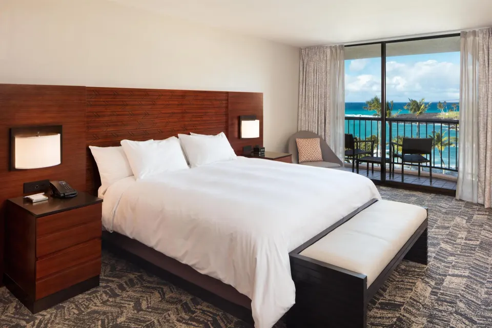 Presidential Suite bedroom with king bed and ocean-view balcony at Hilton Waikoloa Village.