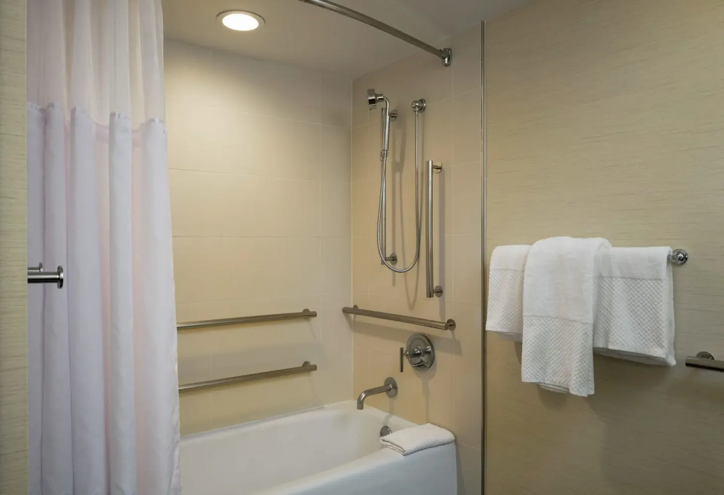 Accessible tub with grab bars in a guest room bathroom at Hilton Waikoloa Village.