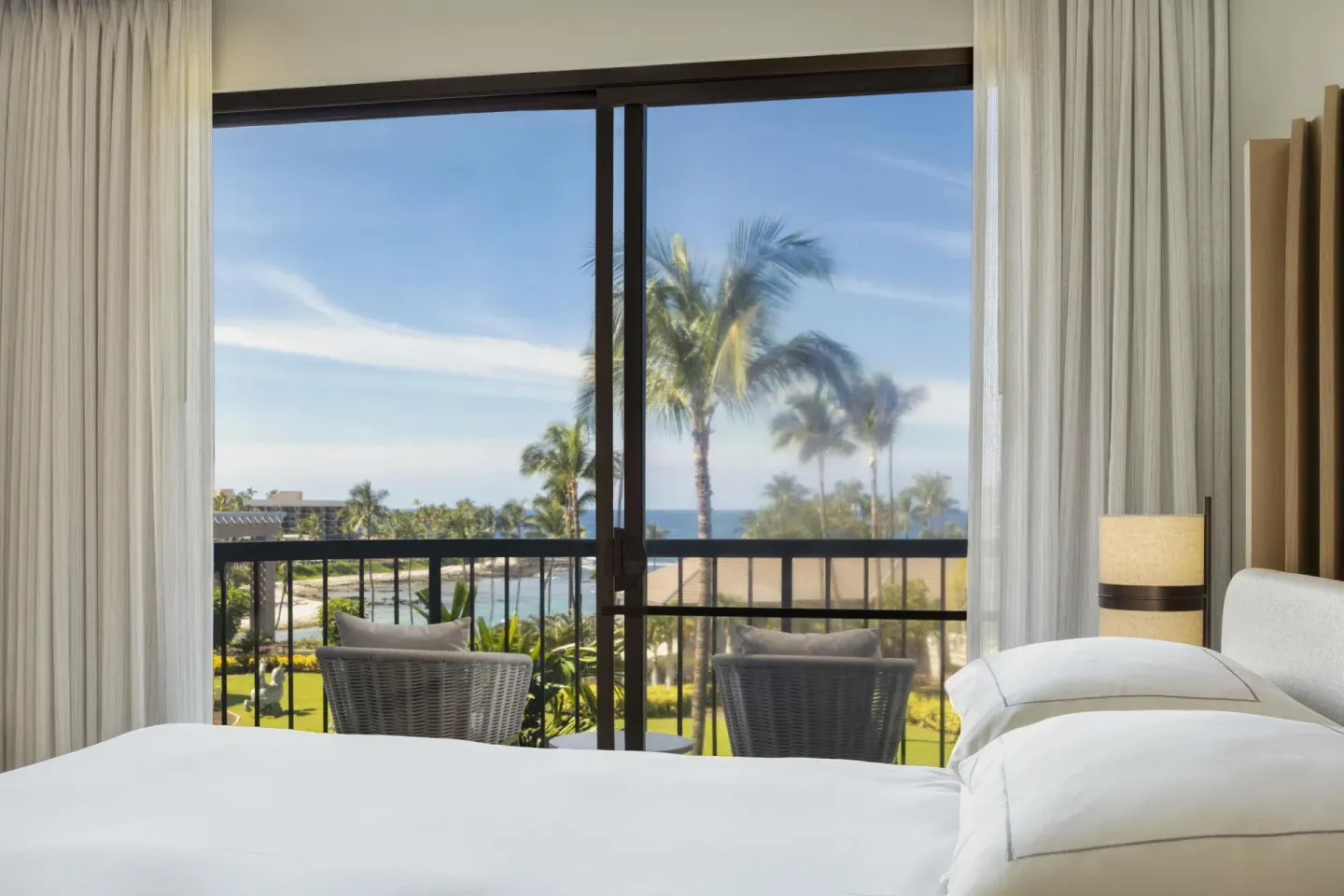 Ocean view guest room bed and balcony at Hilton Waikoloa Village.