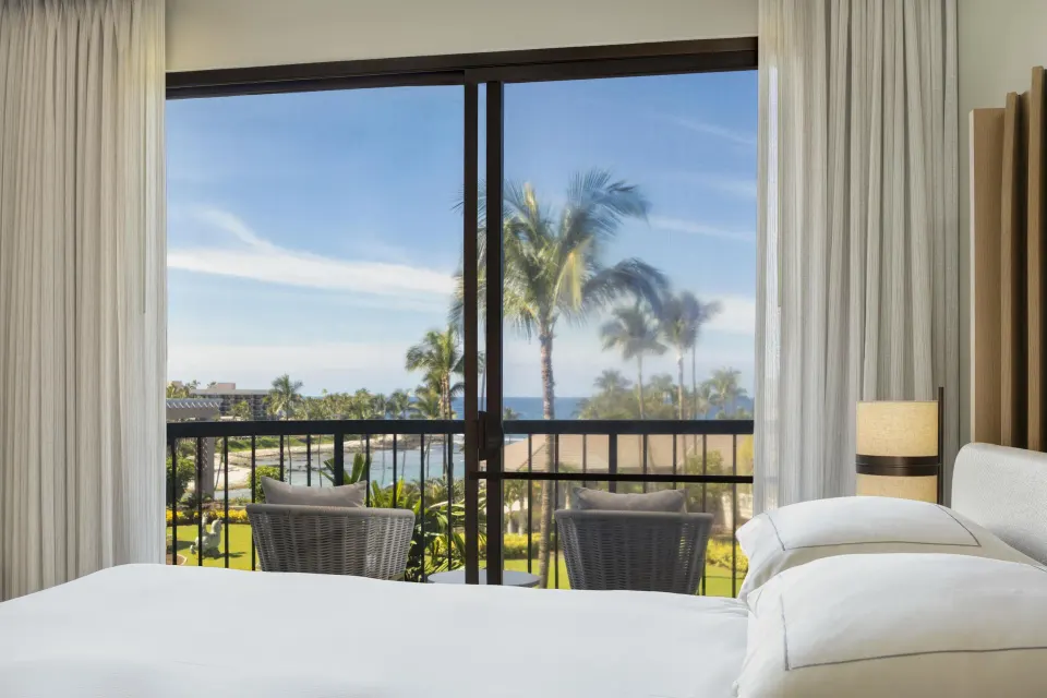 Ocean view guest room bed and balcony at Hilton Waikoloa Village.