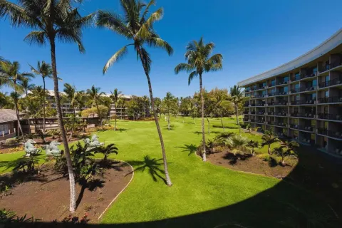 Resort view with palm lawn and guest room balconies at Hilton Waikoloa Village.
