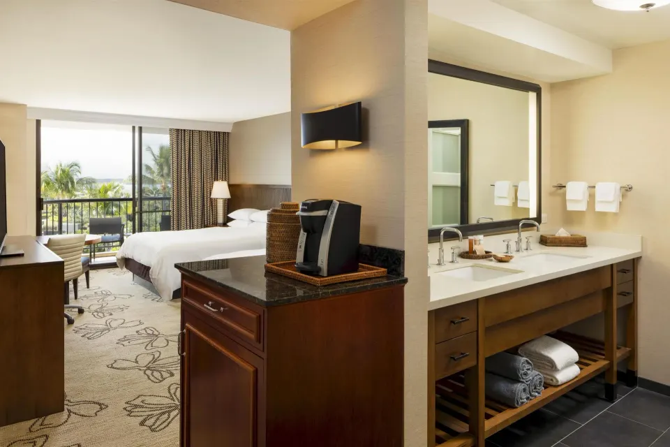 Accessible resort view room with bed, vanity, and coffee station at Hilton Waikoloa Village.