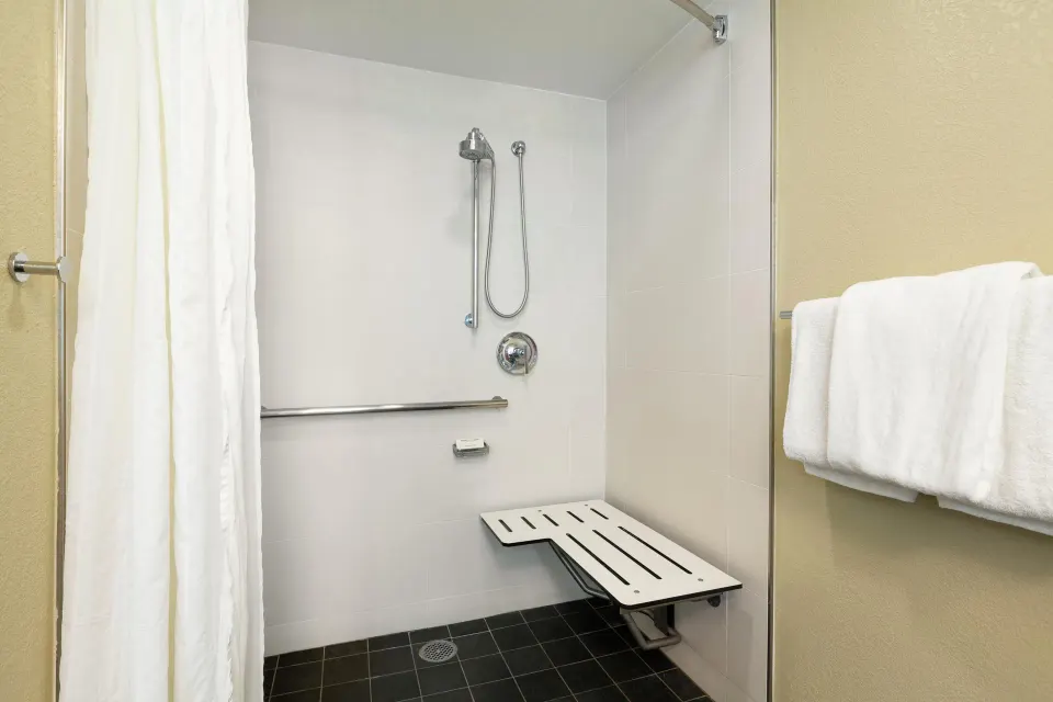 Accessible roll-in shower with bench and grab bars at Hilton Waikoloa Village.