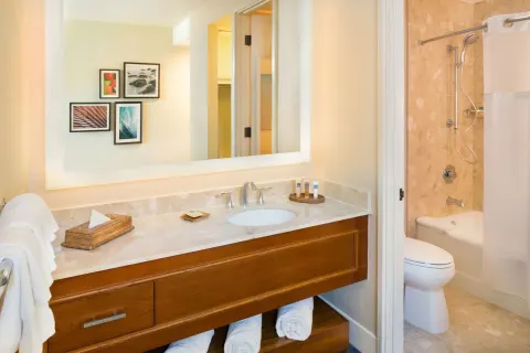 Guest bathroom vanity and tub-shower in an ocean view room at Hilton Waikoloa Village.