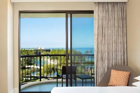 Ocean-view guest room balcony and bed at Hilton Waikoloa Village