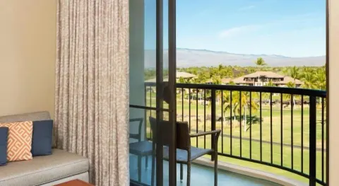 Resort view room sitting area and balcony at Hilton Waikoloa Village.