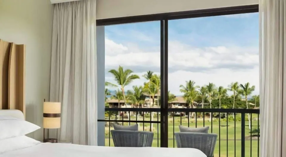 Resort view guest room balcony and bed at Hilton Waikoloa Village.