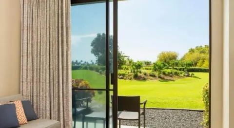 Guest room patio opens to green resort landscaping at Hilton Waikoloa Village.