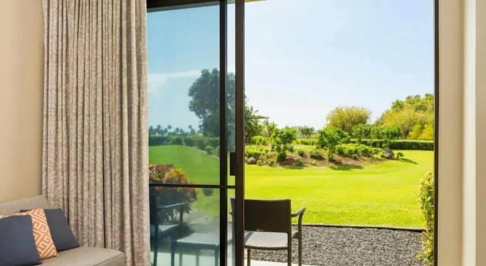 Guest room patio opens to green resort landscaping at Hilton Waikoloa Village.