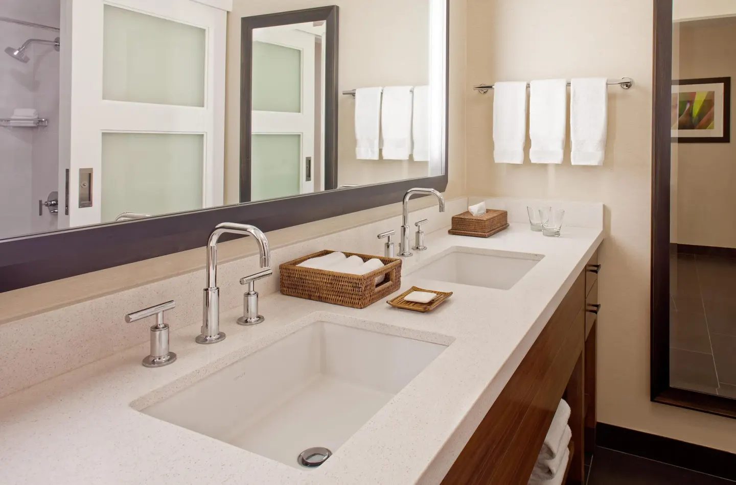 Guest room bathroom with double vanity and shower at Hilton Waikoloa Village.