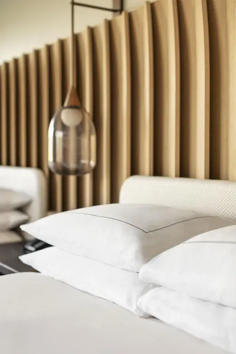 Close-up of pillows, pendant light, and wood headboard in a room at Hilton Waikoloa Village.