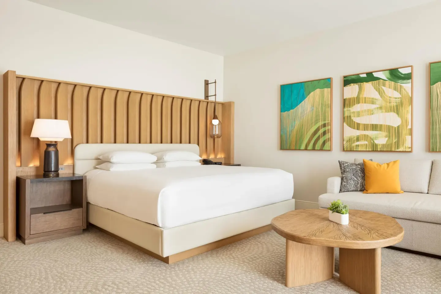 King bed, sofa bed, and coffee table in a renovated room at Hilton Waikoloa Village.