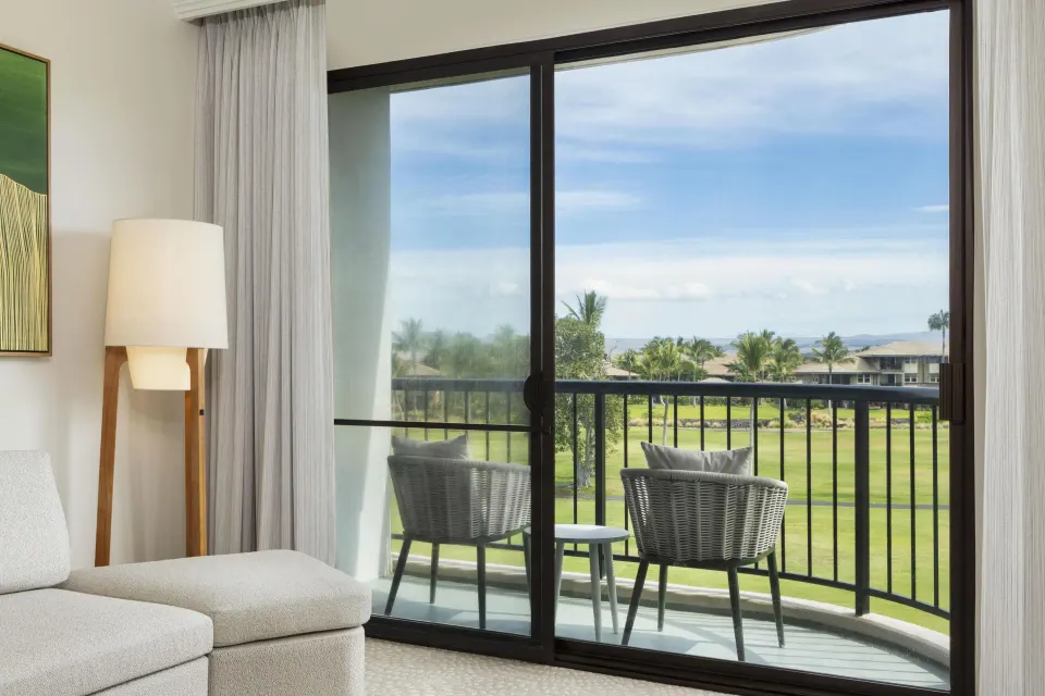 Balcony chairs with golf-course-style resort view from Hilton Waikoloa Village room.
