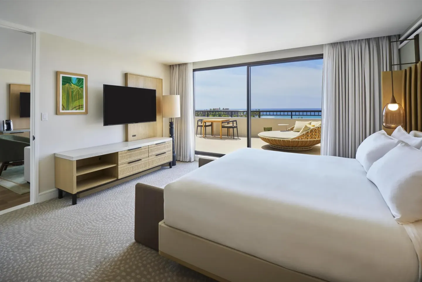 Accessible one-bedroom suite bedroom with king bed and balcony at Hilton Waikoloa Village.