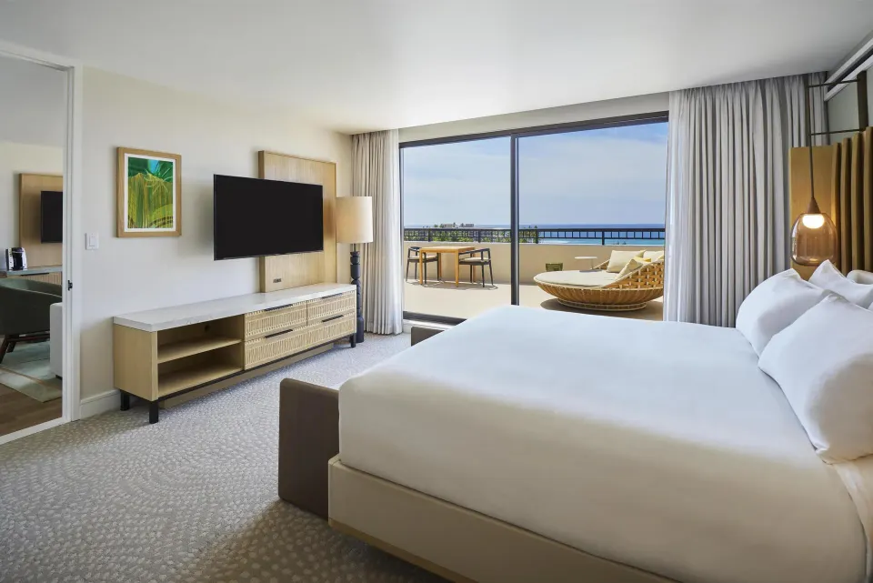 Accessible one-bedroom suite bedroom with king bed and balcony at Hilton Waikoloa Village.