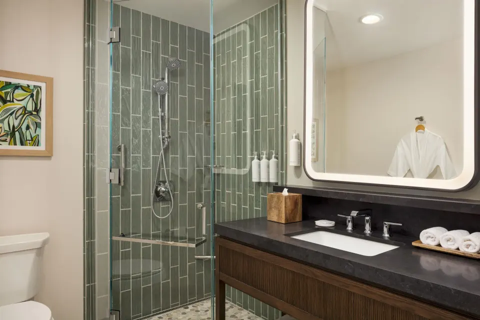 Accessible suite shower and vanity with robe at Hilton Waikoloa Village.