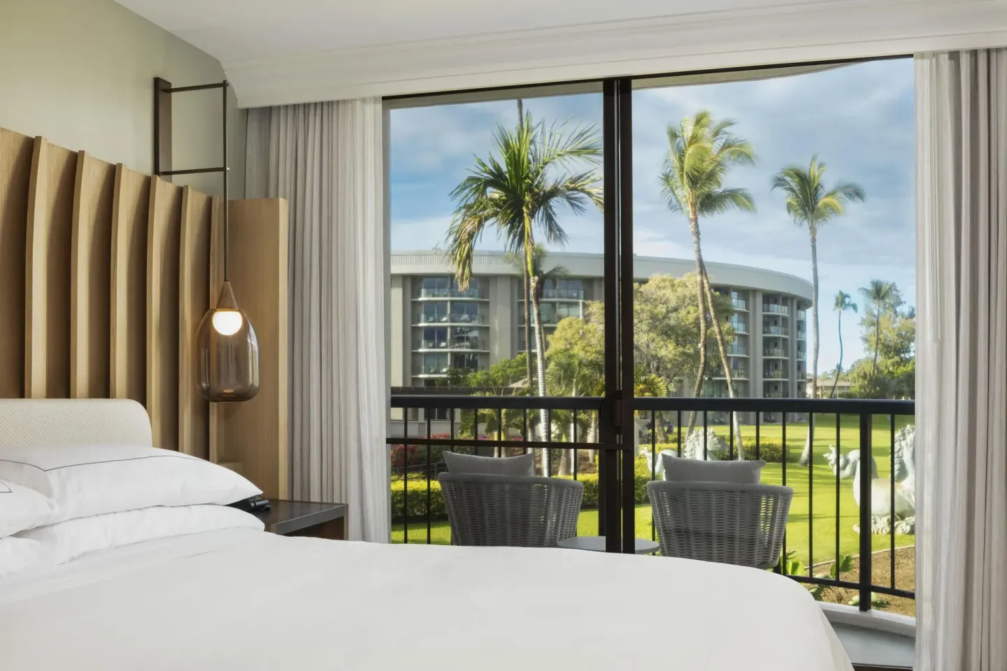Resort view suite bedroom with balcony at Hilton Waikoloa Village.