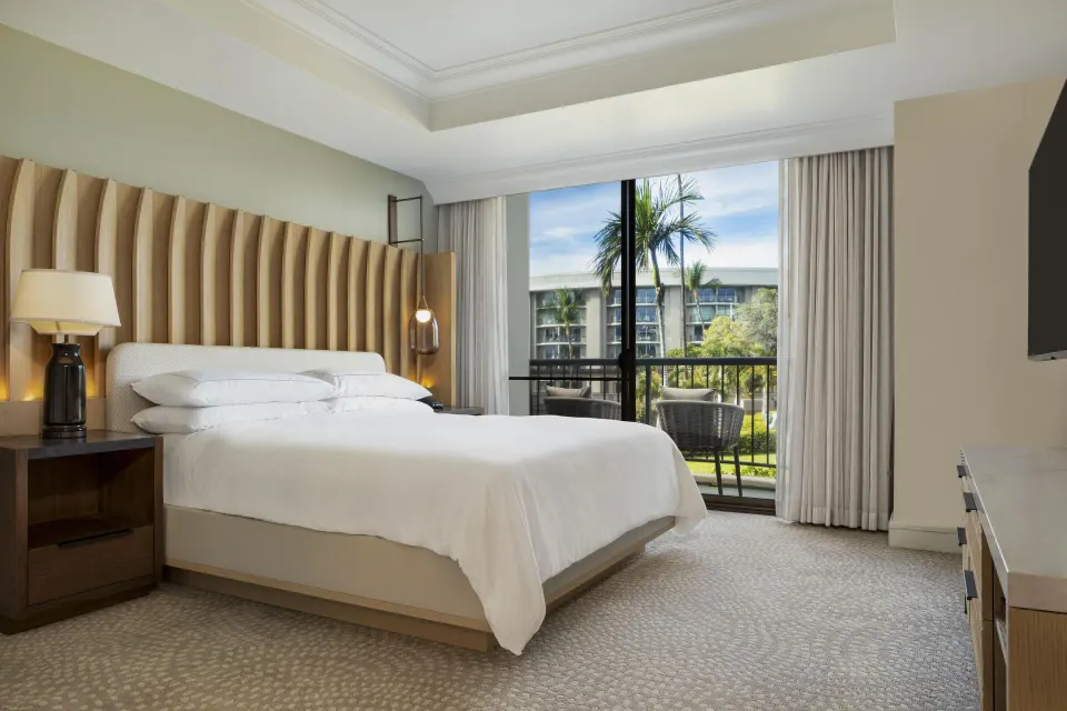 King bed and balcony view in an accessible resort view suite at Hilton Waikoloa Village.